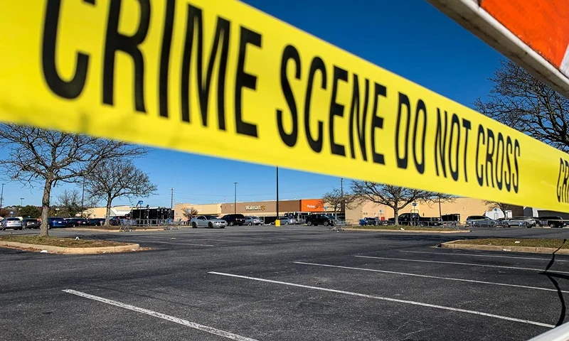 Crime scene tape blocks the parking lot outside of a Walmart following a mass shooting the night before in Chesapeake, Virginia on November 23, 2022. A gunman killed at least six people at a Walmart store Tuesday just ahead of the Thanksgiving holiday in the second mass shooting in the United States in four days. Police later identified the gunman as an employee at the store. (Photo by Bastien INZAURRALDE / AFP) (Photo by BASTIEN INZAURRALDE/AFP via Getty Images)