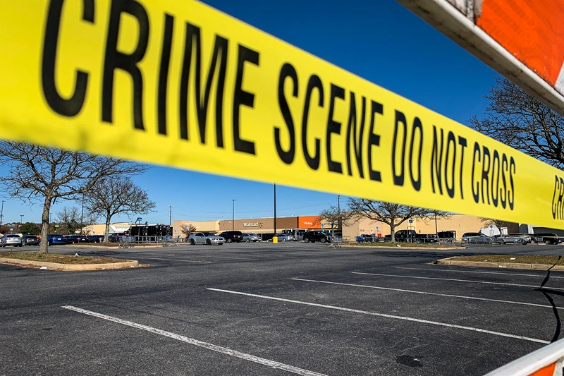Crime scene tape blocks the parking lot outside of a Walmart following a mass shooting the night before in Chesapeake, Virginia on November 23, 2022. A gunman killed at least six people at a Walmart store Tuesday just ahead of the Thanksgiving holiday in the second mass shooting in the United States in four days. Police later identified the gunman as an employee at the store. (Photo by Bastien INZAURRALDE / AFP) (Photo by BASTIEN INZAURRALDE/AFP via Getty Images)
