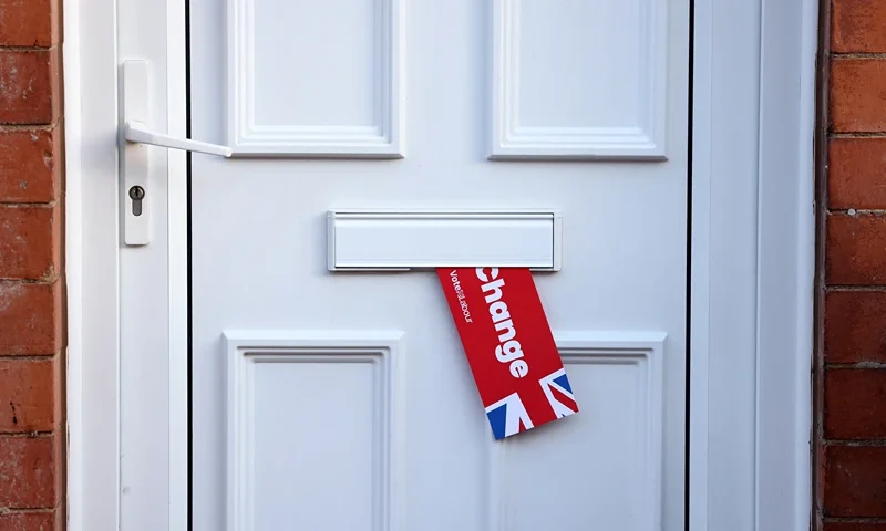 A Labour Party leaflet hangs from a letter box near a polling station in Loughborough, central England, on July 4, 2024 as Britain holds a general election. Voters will cast ballots from 7:00 am (0600 GMT), with polls predicting that Labour will win its first general election since 2005 -- making its leader Keir Starmer prime minister. (Photo by Darren Staples / AFP) (Photo by DARREN STAPLES/AFP via Getty Images