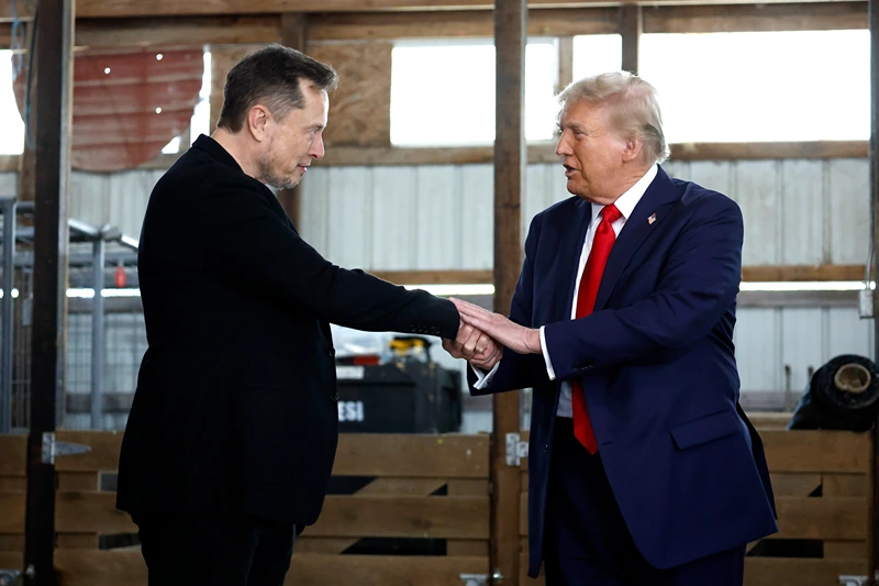 BUTLER, PENNSYLVANIA - OCTOBER 05: Elon Musk (L) shakes hands with Republican presidential nominee, former President Donald Trump back stage during a campaign rally at the Butler Farm Show grounds on October 05, 2024 in Butler, Pennsylvania. This is the first time that Trump has returned to Butler since he was injured during an attempted assassination on July 13. (Photo by Anna Moneymaker/Getty Images)