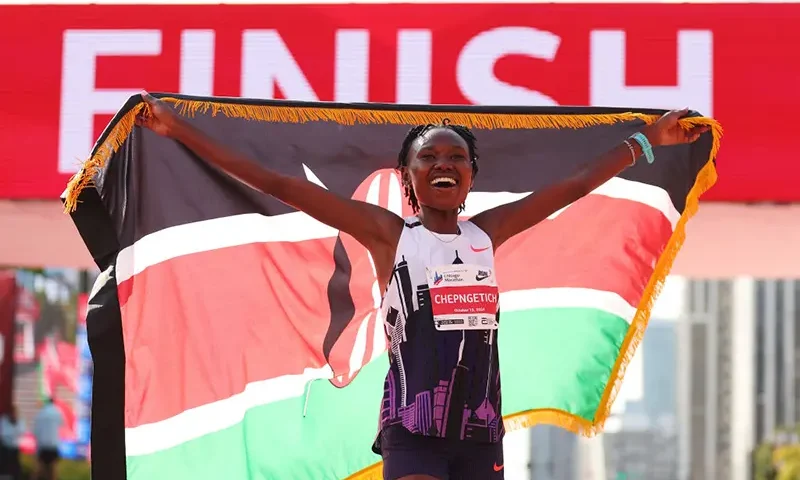 Ruth Chepngetich of Kenya celebrates after crossing the finish line to win the 2024 Chicago Marathon professional women's division and setting a new world record with a time of 2:09:56 at Grant Park on October 13, 2024 in Chicago, Illinois. (Photo by Michael Reaves/Getty Images)