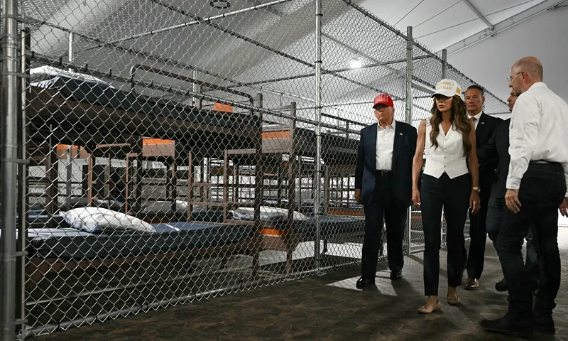 US President President Donald Trump (L), Florida Governor Ron DeSantis (2nd-R), and Secretary of Homeland Security Kristi Noem (2nd-L) tour a migrant detention center, dubbed "Alligator Alcatraz," located at the site of the Dade-Collier Training and Transition Airport in Ochopee, Florida on July 1, 2025. President Trump is visiting a migrant detention center in a reptile-infested Florida swamp dubbed "Alligator Alcatraz." Trump will attend the opening of the 5,000-bed facility -- located at an abandoned airfield in the Everglades wetlands -- part of his expansion of deportations of undocumented migrants, his spokeswoman said. (Photo by ANDREW CABALLERO-REYNOLDS / AFP) (Photo by ANDREW CABALLERO-REYNOLDS/AFP via Getty Images)