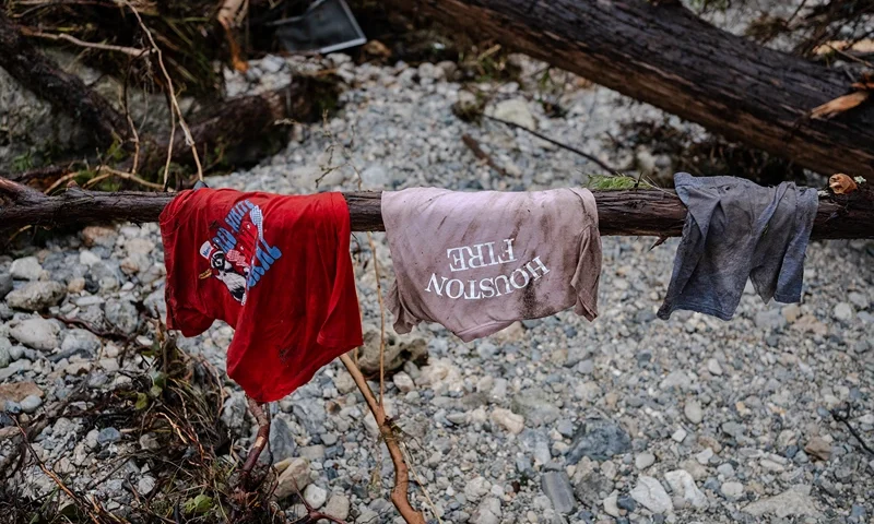 HUNT, TEXAS - JULY 6: Children's clothes hang on the branch of a tree on the bank of the Guadalupe River near Camp Mystic on July 6, 2025 in Hunt, Texas. Heavy rainfall caused flooding along the Guadalupe River in central Texas with multiple fatalities reported. (Photo by Jim Vondruska/Getty Images)
