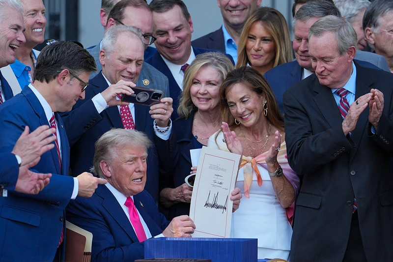 WASHINGTON, DC - JULY 04: U.S. President Donald Trump, joined by Republican lawmakers, signs the One, Big Beautiful Bill Act into law during an Independence Day military family picnic on the South Lawn of the White House on July 04, 2025 in Washington, DC. After weeks of negotiations with Republican holdouts Congress passed the "One, Big Beautiful Bill" Act into law, President Trump’s signature tax and spending bill. The bill makes permanent President Donald Trump’s 2017 tax cuts, increase spending on defense and immigration enforcement and temporarily cut taxes on tips, while cutting funding for Medicaid, food assistance and other social safety net programs. (Photo by Eric Lee/Getty Images)
