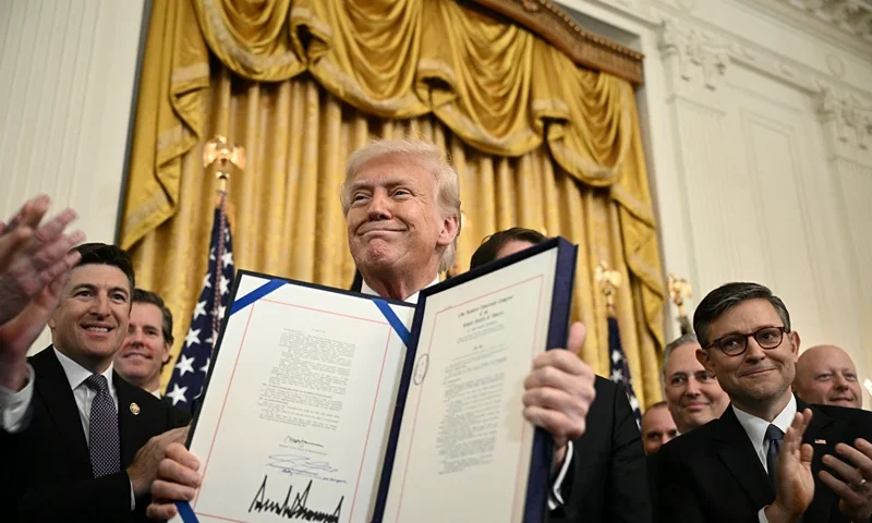 US President Donald Trump displays the GENIUS Act (Guiding and Establishing National Innovation for US Stablecoins Act), which codifies the use of stablecoins -- cryptocurrencies pegged to stable assets like the US dollar or US bonds -- after signing it in the East Room of the White House in Washington, DC, on July 18, 2025. (Photo by Brendan SMIALOWSKI / AFP) (Photo by BRENDAN SMIALOWSKI/AFP via Getty Images)