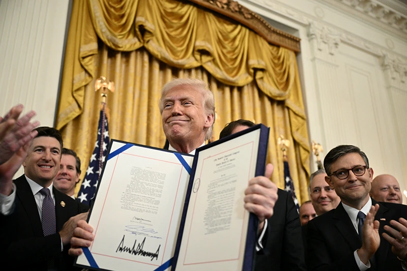 US President Donald Trump displays the GENIUS Act (Guiding and Establishing National Innovation for US Stablecoins Act), which codifies the use of stablecoins -- cryptocurrencies pegged to stable assets like the US dollar or US bonds -- after signing it in the East Room of the White House in Washington, DC, on July 18, 2025. (Photo by Brendan SMIALOWSKI / AFP) (Photo by BRENDAN SMIALOWSKI/AFP via Getty Images)