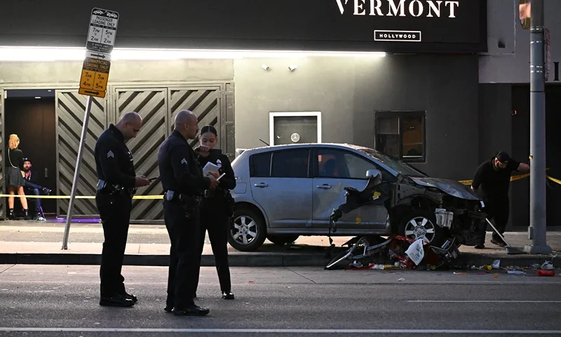 Officers stand at the scene of a crashed vehicle which drove into a crowd in Hollywood in the early hours of July 19, 2025, injuring 28 people, according to the Los Angeles Fire Department. More than 100 firefighters responded to the scene in East Hollywood assisting three patients in critical condition, six in serious condition and 19 listed as fair, the Fire Department said. (Photo by Robyn Beck / AFP) (Photo by ROBYN BECK/AFP via Getty Images)