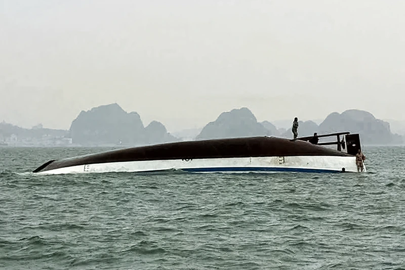 A man stands on a tourist boat that capsized in Ha Long Bay, Quang Ninh province on July 19, 2025. At least 18 people have died and dozens remain missing after a tourist boat carrying more than 50 people capsized on July 19, in Vietnam's Ha Long Bay, state media said. (Photo by AFP) (Photo by -/AFP via Getty Images)