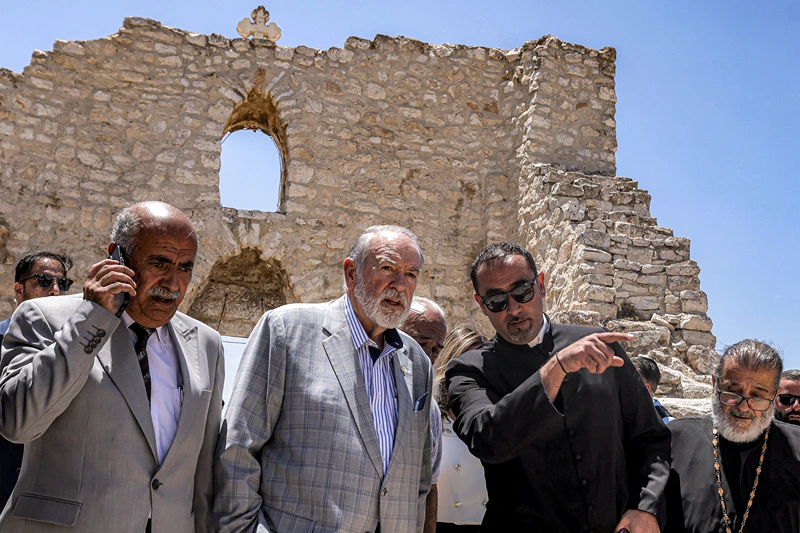 TOPSHOT - US ambassador to Israel Mike Huckabee (C) and the Palestinian mayor of the village of Taybeh, Suleiman Khourieh (L), tour the fifth-century Church of St George in the Palestinian Christian village of Taybeh, northeast of Ramallah in the occupied West Bank, on July 19, 2025. In the villages and communities around Taybeh, Palestinian authorities have reported that settlers had killed three people and damaged or destroyed multiple water sources in the past two weeks alone. The July 7 arson attack on the remains of the Church of Saint George, which date back to the 5th century, was the last straw for many villagers, who blame Israeli settlers for a spate of recent attacks. (Photo by JAAFAR ASHTIYEH / AFP) (Photo by JAAFAR ASHTIYEH/AFP via Getty Images)