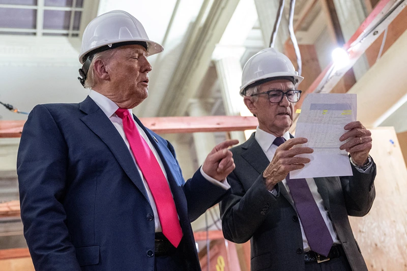US President Donald Trump points to a cost sheet as he speaks with Federal Reserve chair Jerome Powell (R) as he visits the Federal Reserve in Washington, DC, on July 24, 2025. Trump arrived for a tour of the US Federal Reserve as the president escalates pressure on its chairman Jerome Powell over the central bank's management of the economy. Trump -- who wants to oust Powell for refusing to lower interest rates but likely lacks the legal authority -- has threatened to fire the Fed chief over cost overruns for a renovation of its Washington headquarters. (Photo by ANDREW CABALLERO-REYNOLDS / AFP) (Photo by ANDREW CABALLERO-REYNOLDS/AFP via Getty Images)