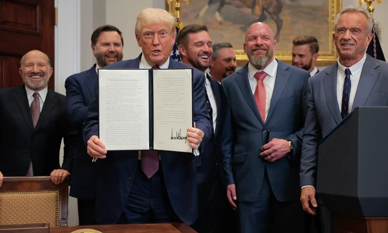 WASHINGTON, DC - JULY 31: U.S. President Donald Trump (C) displays a signed executive order during a signing ceremony in the Roosevelt Room of the White House on July 31, 2025 in Washington, DC. Standing with Trump are (L-R) Commerce Secretary Howard Lutnick, Vice President JD Vance, golfer Bryson DeChambeau, WWE Chief Creative Officer Paul “Triple H” Levesque, and US Secretary of Health and Human Services Robert F. Kennedy Jr. Trump signed a series of orders that will expand on his council on sports, fitness and nutrition, including by reviving the Presidential Fitness Test in public schools. (Photo by Anna Moneymaker/Getty Images)