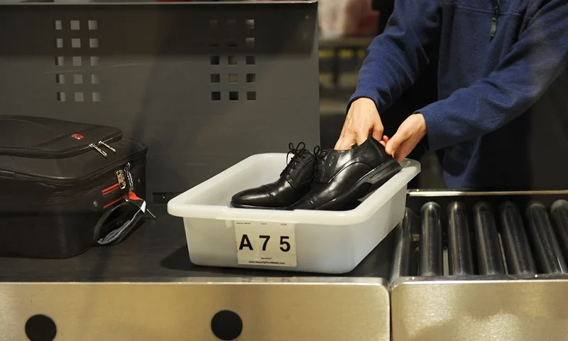 An air traveler places his shoes in a bin before passing through the Transportation Security Administration (TSA) security check at Los Angeles International Airport (LAX) on February 20, 2014 in Los Angeles, California. The TSA recently launched a PreCheck program that allows those enrolled in a trusted traveler network to enter about 100 US airports through a special security lane where they dont have to take off shoes, belts and jackets or remove laptops, liquids or gels. AFP PHOTO / ROBYN BECK (Photo credit should read ROBYN BECK/AFP via Getty Images)