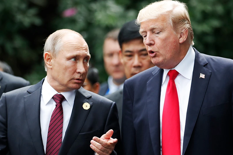 US President Donald Trump (R) and Russia's President Vladimir Putin talk as they make their way to take the "family photo" during the Asia-Pacific Economic Cooperation (APEC) leaders' summit in the central Vietnamese city of Danang on November 11, 2017. World leaders and senior business figures are gathering in the Vietnamese city of Danang this week for the annual 21-member APEC summit. (Photo by JORGE SILVA / POOL / AFP) (Photo by JORGE SILVA/POOL/AFP via Getty Images)