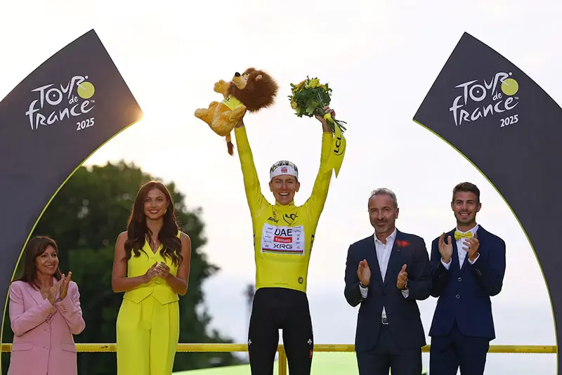 UAE Team Emirates XRG's Tadej Pogacar celebrates on the podium wearing the yellow jersey after winning the Tour de France, as Paris' mayor Anne Hidalgo applauds REUTERS/Sarah Meyssonnier