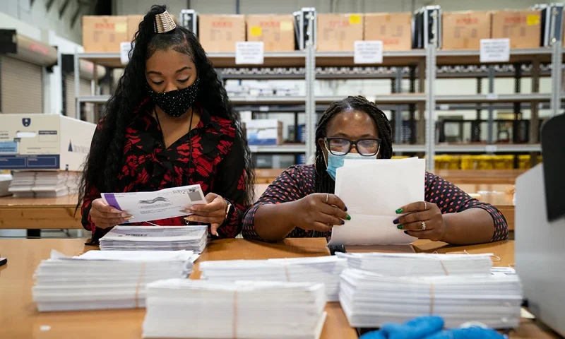 GLEN BURNIE, MD - OCTOBER 07: Working in bipartisan pairs, canvassers process mail-in ballots in a warehouse at the Anne Arundel County Board of Elections headquarters on October 7, 2020 in Glen Burnie, Maryland. The ballot canvas for mail-in and absentee ballots began on October 1st in Maryland, the earliest in the country. Every ballot goes through a five step process before being sliced open and tabulated. (Photo by Drew Angerer/Getty Images)