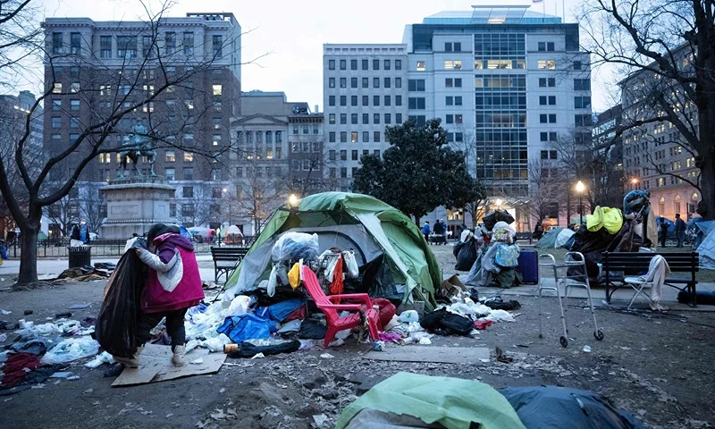 A woman packs her belongings before members of the US National Park Service clear a homeless encampment from McPherson Square two blocks from the White House in Washington, DC on February 15, 2023. - Some 56 people live in the federal park, which is being cleared ahead of the initial April schedule due to safety concerns. (Photo by Brendan Smialowski / AFP) (Photo by BRENDAN SMIALOWSKI/AFP via Getty Images)