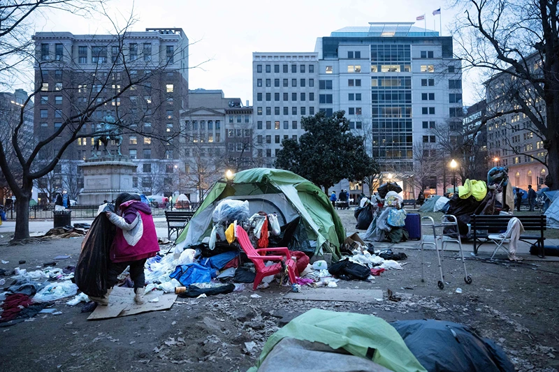 A woman packs her belongings before members of the US National Park Service clear a homeless encampment from McPherson Square two blocks from the White House in Washington, DC on February 15, 2023. - Some 56 people live in the federal park, which is being cleared ahead of the initial April schedule due to safety concerns. (Photo by Brendan Smialowski / AFP) (Photo by BRENDAN SMIALOWSKI/AFP via Getty Images)