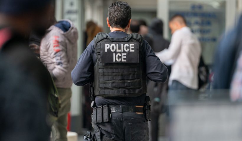 NEW YORK, NEW YORK - JUNE 6: An ICE agent monitors hundreds of asylum seekers being processed upon entering the Jacob K. Javits Federal Building on June 6, 2023 in New York City. New York City has provided sanctuary to over 46,000 asylum seekers since 2013, when the city passed a law prohibiting city agencies from cooperating with federal immigration enforcement agencies unless there is a warrant for the person's arrest.(Photo by David Dee Delgado/Getty Images)
