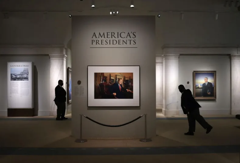 WASHINGTON, DC - MAY 14: Patrons and security guards view a portrait of former U.S. President Donald Trump in the America’s Presidents exhibition at the National Portrait Gallery as the Smithsonian Institution begins to slowly re-open its museums May 14, 2021 in Washington, DC. Trump’s portrait, a photograph made by Pari Dukovic is on display to the public for the first time since the closure of the museums due to the coronavirus pandemic. (Photo by Win McNamee/Getty Images)
