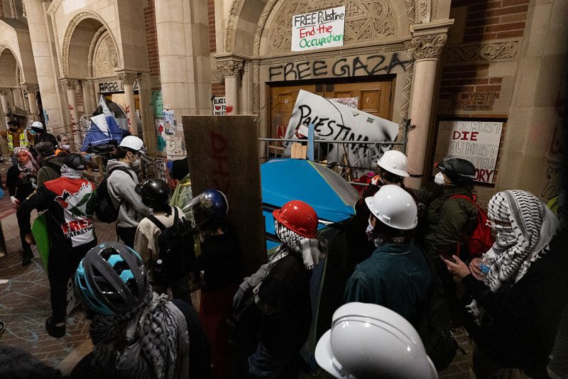 Protesters reinforce the barricades set up against one of the doors of Royce Hall as police started clearing a pro-Palestinian encampment on the campus of the University of California, Los Angeles (UCLA) in Los Angeles, California, early on May 2, 2024. Hundreds of police tore down protest barricades and began arresting students early Thursday at the University of California, Los Angeles - the latest flashpoint in an eruption of protest on US campuses over Israel's war against Hamas in Gaza. (Photo by ETIENNE LAURENT / AFP) (Photo by ETIENNE LAURENT/AFP via Getty Images)
