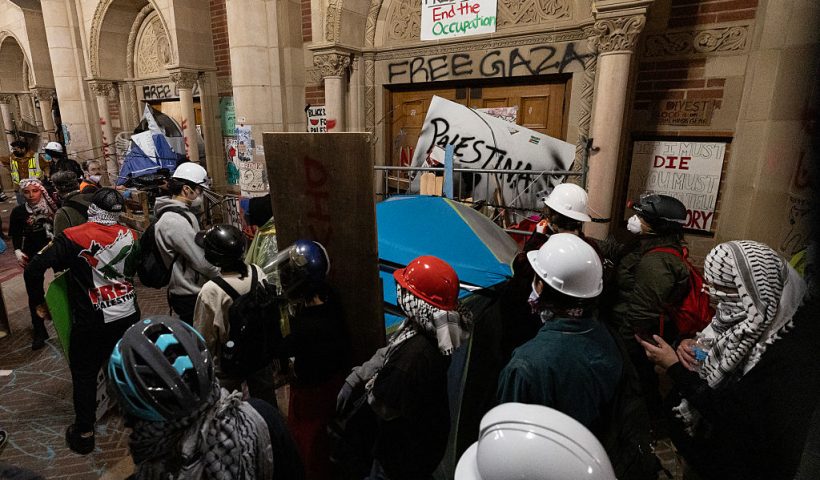 Protesters reinforce the barricades set up against one of the doors of Royce Hall as police started clearing a pro-Palestinian encampment on the campus of the University of California, Los Angeles (UCLA) in Los Angeles, California, early on May 2, 2024. Hundreds of police tore down protest barricades and began arresting students early Thursday at the University of California, Los Angeles - the latest flashpoint in an eruption of protest on US campuses over Israel's war against Hamas in Gaza. (Photo by ETIENNE LAURENT / AFP) (Photo by ETIENNE LAURENT/AFP via Getty Images)
