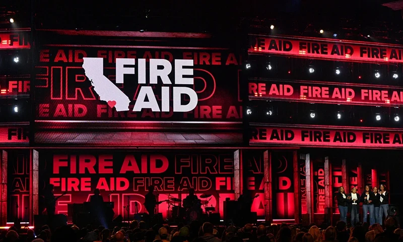 INGLEWOOD, CALIFORNIA - JANUARY 30: Eshele Williams (C) and family speak onstage during the FIREAID Benefit Concert for California Fire Relief at The Kia Forum on January 30, 2025 in Inglewood, California. (Photo by Scott Dudelson/Getty Images for FIREAID)