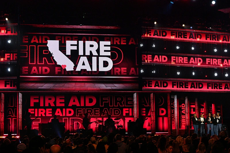 INGLEWOOD, CALIFORNIA - JANUARY 30: Eshele Williams (C) and family speak onstage during the FIREAID Benefit Concert for California Fire Relief at The Kia Forum on January 30, 2025 in Inglewood, California. (Photo by Scott Dudelson/Getty Images for FIREAID)