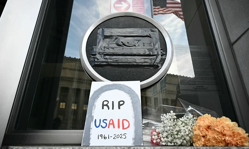TOPSHOT - Tributes are placed beneath the covered seal of the US Agency for International Development (USAID) at their headquarters in Washington, DC, on February 7, 2025. US President Donald Trump on February 7, 2025 called for USAID to be shuttered, escalating his unprecedented campaign to dismantle the humanitarian agency. (Photo by Mandel NGAN / AFP) (Photo by MANDEL NGAN/AFP via Getty Images)