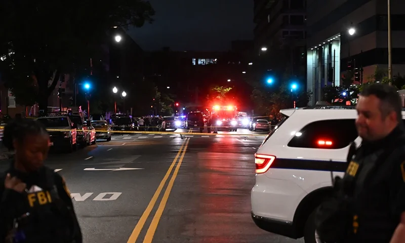Emergency vehicles are seen in the distance as FBI agents guard the scene outside the Capital Jewish Museum following a shooting that left two people dead, in Washington, DC, in the early hours of May 22, 2025. Two Israeli embassy staffers were shot dead late Wednesday, May 21, outside a Jewish museum in Washington by a gunman who shouted "free Palestine," authorities said, with US officials and Israeli diplomats expressing shock and outrage over the killings. (Photo by Alex WROBLEWSKI / AFP) (Photo by ALEX WROBLEWSKI/AFP via Getty Images)