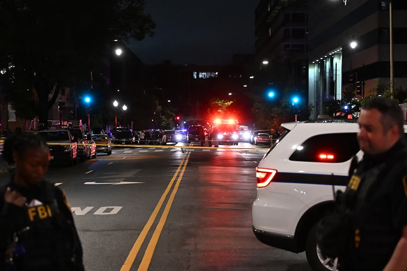 Emergency vehicles are seen in the distance as FBI agents guard the scene outside the Capital Jewish Museum following a shooting that left two people dead, in Washington, DC, in the early hours of May 22, 2025. Two Israeli embassy staffers were shot dead late Wednesday, May 21, outside a Jewish museum in Washington by a gunman who shouted "free Palestine," authorities said, with US officials and Israeli diplomats expressing shock and outrage over the killings. (Photo by Alex WROBLEWSKI / AFP) (Photo by ALEX WROBLEWSKI/AFP via Getty Images)