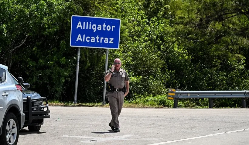 A Florida Highway Patrol officer looks on as protesters gather to demand the closure of the immigrant detention center known as "Alligator Alcatraz" at the Dade-Collier Training and Transition Airport in Ochopee, Florida, on July 22, 2025. Immigrants held at US detention centers have experienced abusive and degrading treatment, a Human Rights Watch report said on July 21. (Photo by CHANDAN KHANNA / AFP) (Photo by CHANDAN KHANNA/AFP via Getty Images)