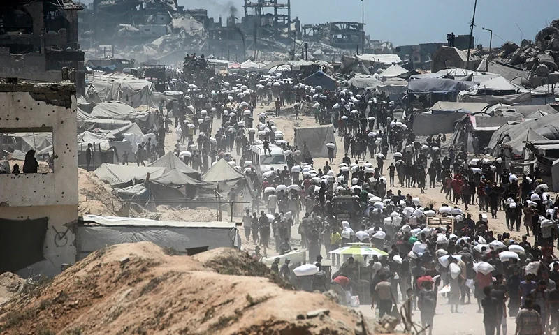TOPSHOT - Palestinians carry bags of flour that they obtained from aid trucks which entered Gaza through the Zikim crossing point, in Jabalia in the northern Gaza Strip on August 1, 2025. The UN human rights office said on August 1 that 1,373 Palestinians have been killed while waiting for aid in the shortage-stricken Gaza Strip since late May, most of them by the Israeli military. (Photo by Bashar TALEB / AFP) (Photo by BASHAR TALEB/AFP via Getty Images)