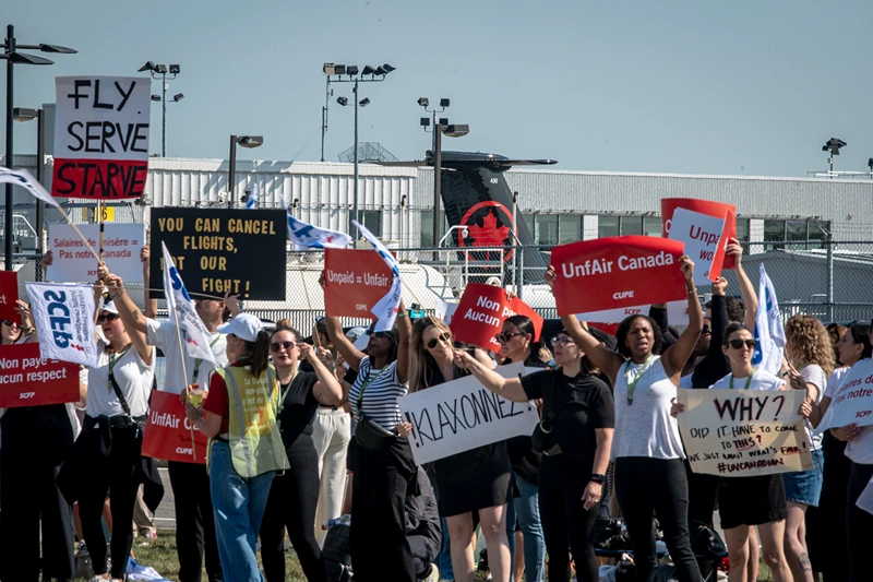 Air Canada flight attendants participate in a general strike at Montréal-Pierre Elliott Trudeau International Airport on August 16, 2025 in Montreal, Canada. After more than 10,000 Air Canada flight attendants went on strike early this morning, the country's largest airline has been forced to suspend operations and cancel all of its 700 daily flights. (Photo by Andrej Ivanov/Getty Images)