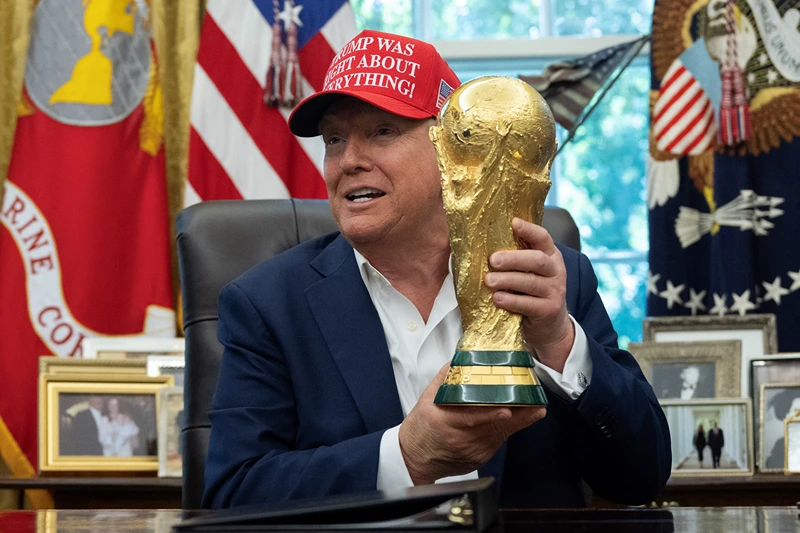 US President Donald Trump holds the World Cup trophy in the Oval Office of the White House in Washington, DC, on August 22, 2025. Trump announced the 2026 World Cup draw will be held on December 5 at Washington's Kennedy Center. (Photo by ANDREW CABALLERO-REYNOLDS / AFP) (Photo by ANDREW CABALLERO-REYNOLDS/AFP via Getty Images)