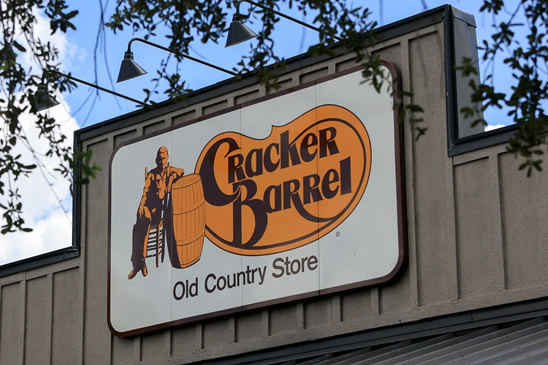 PEMBROKE PINES, FLORIDA - AUGUST 21: A Cracker Barrel sign featuring the old logo hangs on the outside of a restaurant on August 21, 2025 in Homestead, Florida. The restaurant unveiled a new logo earlier this week as part of a larger brand refresh. The new logo removes the image of a man sitting next to a barrel and the phrase “old country store”. Now the logo will feature the words “Cracker Barrel” against a yellow background. (Photo by Joe Raedle/Getty Images)
