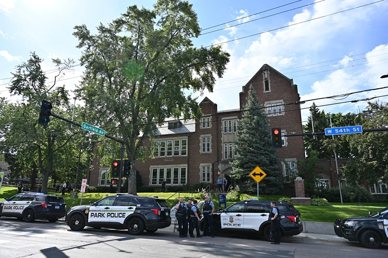 Police and first responders work at the scene of a shooting near Annunciation Church and Catholic School in Minneapolis, Minneosta, on August 27, 2025. Two children were shot dead when a gunman attacked a Minneapolis church on Wednesday, with 17 people injured, 14 of them children, police said. The gunman "began firing a rifle through the church windows towards the children sitting in the pews at the mass," Minneapolis police chief Brian O'Hara told reporters. The pupils were marking the first week of the school year when the attack occurred. (Photo by TOM BAKER / AFP) (Photo by TOM BAKER/AFP via Getty Images)