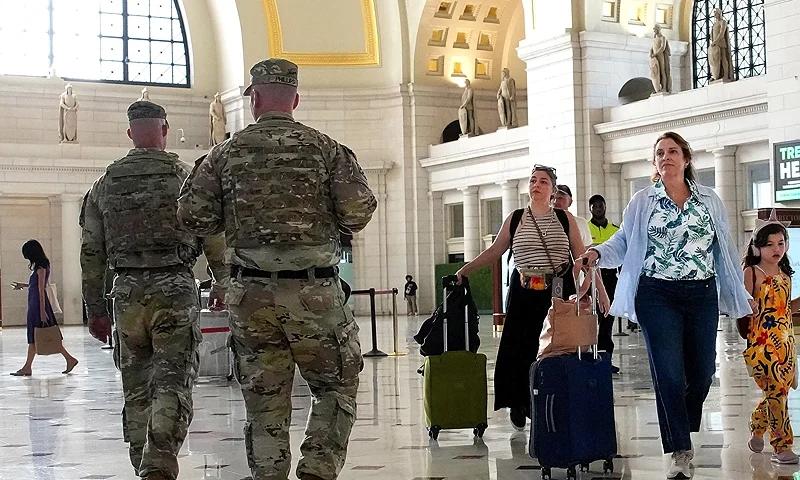 WASHINGTON, DC - AUGUST 25: Travelers arrive alongside patrolling National Guard soldiers at Union Station on August 25, 2025 in Washington, DC. The Trump administration has deployed federal officers and the National Guard to the District in order to place the DC Metropolitan Police Department under federal control and assist in crime prevention in the nation's capital. (Photo by Kevin Dietsch/Getty Images)