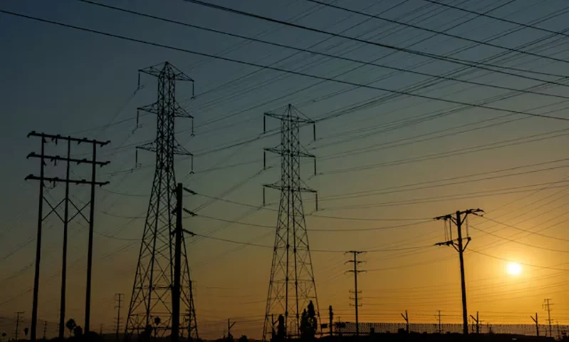 Electrical transmission towers and lines are shown in the early morning of a hot summer day in Commerce, California, U.S, August 7, 2025. REUTERS/Mike Blake/File Photo