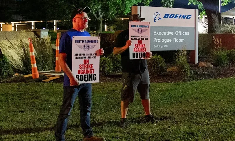 Workers display picket signs, as they protest during a walkout by members of the International Association of Machinists and Aerospace Workers (IAM) over contract negotiations, outside Boeing company's facility, in Berkeley, Missouri, U.S., August 4, 2025 REUTERS/Lawrence Bryant