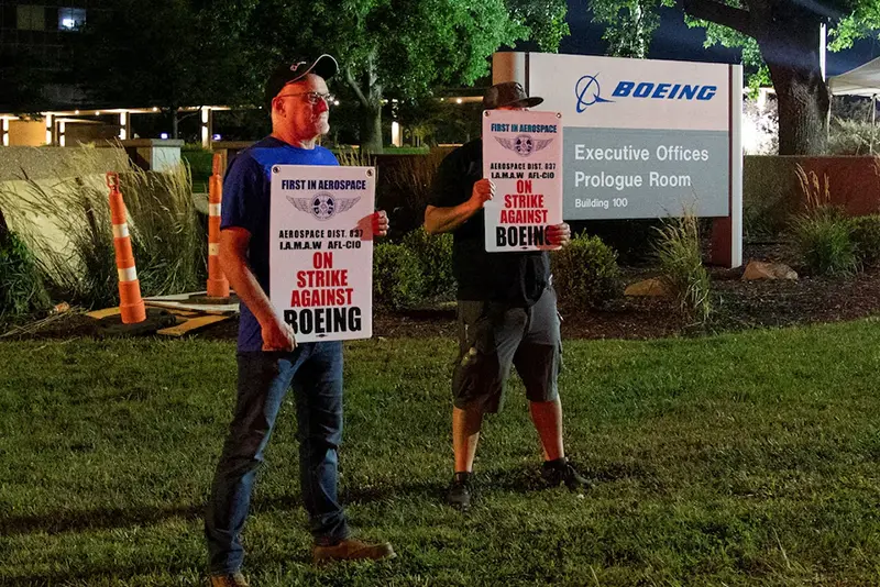 Workers display picket signs, as they protest during a walkout by members of the International Association of Machinists and Aerospace Workers (IAM) over contract negotiations, outside Boeing company's facility, in Berkeley, Missouri, U.S., August 4, 2025 REUTERS/Lawrence Bryant