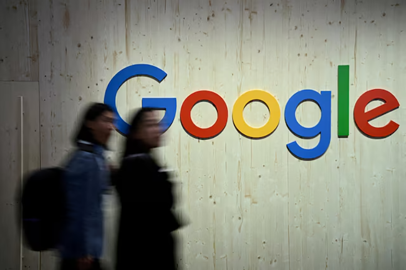 People walk next to a Google logo during a trade fair in Hannover Messe, in Hanover, Germany, April 22, 2024. REUTERS/Annegret Hilse/File Photo