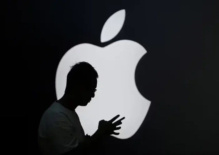 A man check his phone near an Apple logo outside its store in Shanghai, China September 13, 2023. REUTERS/Aly Song/ File Photo