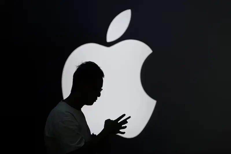 A man check his phone near an Apple logo outside its store in Shanghai, China September 13, 2023. REUTERS/Aly Song/ File Photo