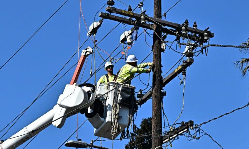 Workers from PG&E work on repairing and restoring power lines on January 13, 2025 in Altadena, California, where the devastating Eaton Fire caused widespread damage. Homeowners and renters who lost their homes due to the fire are suing Southern California Edison, alleging the electrical utility that provides electricity to some 15 million people in a 50,000 square-mile area of Southern California failed to de-energize its electrical equipment despite the high wind and red flag warnings issues by the National Weather Service. (Photo by Frederic J. BROWN / AFP) (Photo by FREDERIC J. BROWN/AFP via Getty Images)