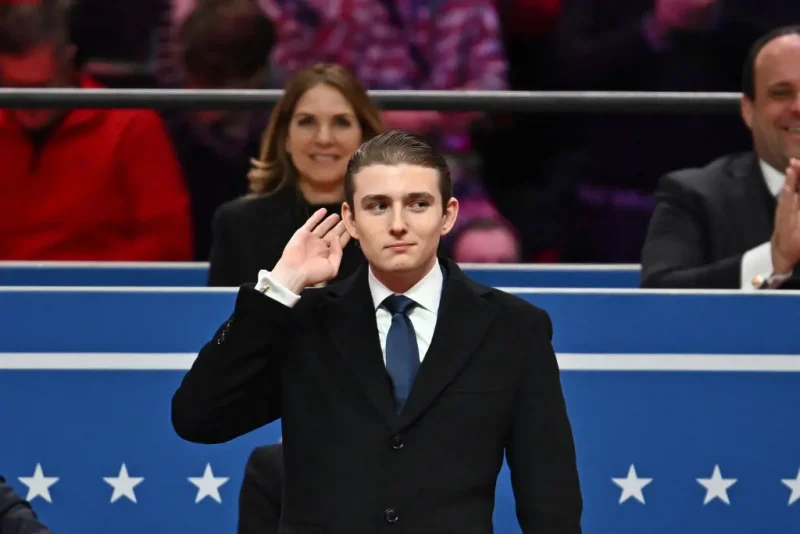 TOPSHOT - Barron Trump gestures after being acknowledged by his father US President Donald Trump during the inaugural parade inside Capital One Arena, in Washington, DC, on January 20, 2025. (Photo by ANGELA WEISS / AFP) (Photo by ANGELA WEISS/AFP via Getty Images)