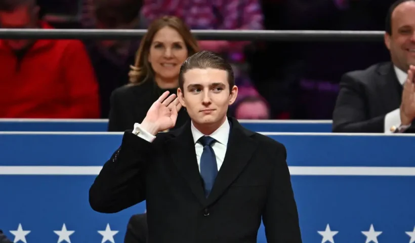 TOPSHOT - Barron Trump gestures after being acknowledged by his father US President Donald Trump during the inaugural parade inside Capital One Arena, in Washington, DC, on January 20, 2025. (Photo by ANGELA WEISS / AFP) (Photo by ANGELA WEISS/AFP via Getty Images)