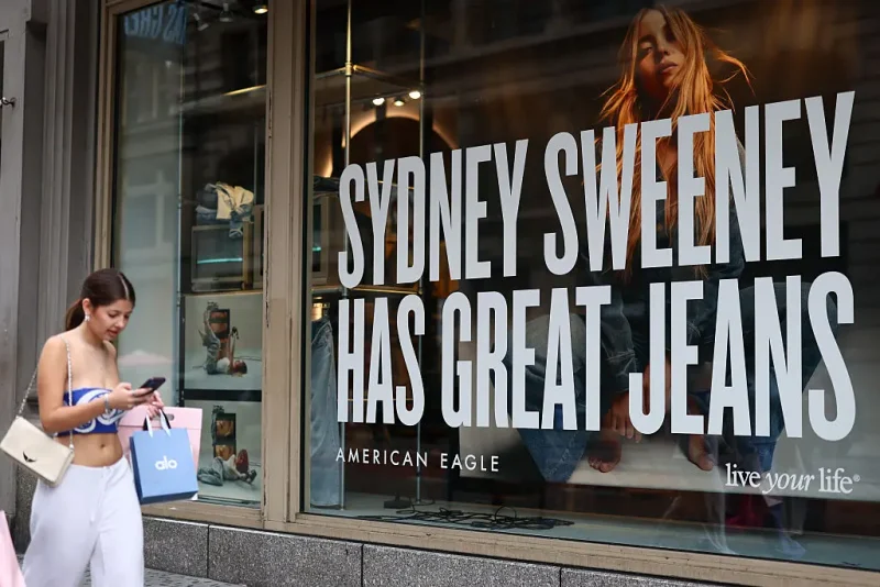 NEW YORK, NEW YORK - AUGUST 01: A window display of actress Sydney Sweeney is seen on a window of an American Eagle store on August 01, 2025 in New York City. American Eagle’s recent denim ad campaign featuring Sweeney has drawn backlash for language and imagery that critics say echoes eugenics-era rhetoric, following a tagline referencing “great genes” alongside visuals of Sweeney in blue jeans. (Photo by Michael M. Santiago/Getty Images)