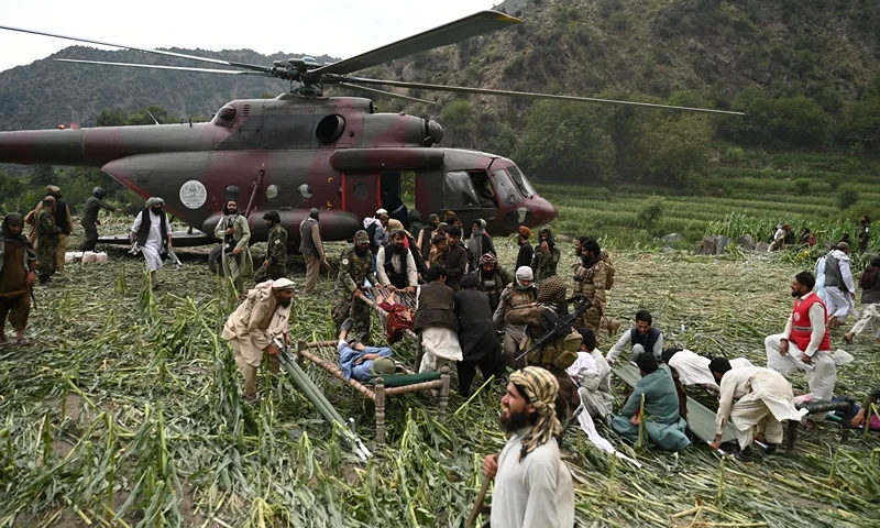 Afghan volunteers and Taliban security personnel work to move injured people near a military helicopter following earthquakes in the Mazar Dara village of Nurgal, a district of the Kunar Province, in Eastern Afghanistan, on September 1, 2025. More than 800 people have died and over 2,700 were injured from August 31 night to September 1, 2025, in eastern Afghanistan after a 6-magnitude earthquake, followed by at least five aftershocks felt hundreds of kilometers away. (Photo by Wakil Kohsar / AFP) (Photo by WAKIL KOHSAR/AFP via Getty Images)