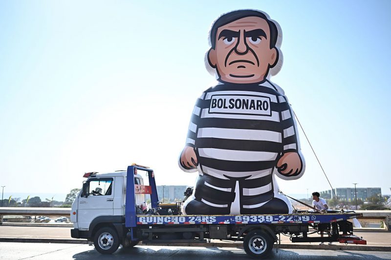 BRASILIA, BRAZIL - SEPTEMBER 12: A truck carries an inflatable doll representing former President of Brazil Jair Bolsonaro in prison uniform the day after Supreme Court of Brazil confirmed his prison sentence on September 12, 2025 in Brasilia, Brazil. Bolsonaro ruled the country between 2019 and 2022 and has been sentenced to 27 years in prison over a coup plot after being defeated by Lula Da Silva in the 2022 presidential election. The right-wing former president also faces four more charges against the democratic order. (Photo by Ton Molina/Getty Images)