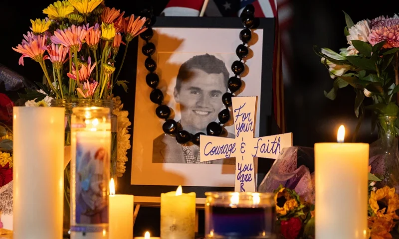 Candles and flowers are seen near a portrait of right-wing activist Charlie Kirk at a makeshift memorial during a candlelight vigil at Memorial Park in Provo, Utah, on September 12, 2025, after he was shot during a public event at Utah Valley University. The widow of prominent right-wing activist Charlie Kirk pledged on September 12 to carry on her husband's work, after US authorities announced his alleged assassin had finally been captured. The 31-year-old Kirk was hit by a single bullet while addressing a large crowd at Utah Valley University in the town of Orem on September 10. (Photo by Melissa MAJCHRZAK / AFP) (Photo by MELISSA MAJCHRZAK/AFP via Getty Images)